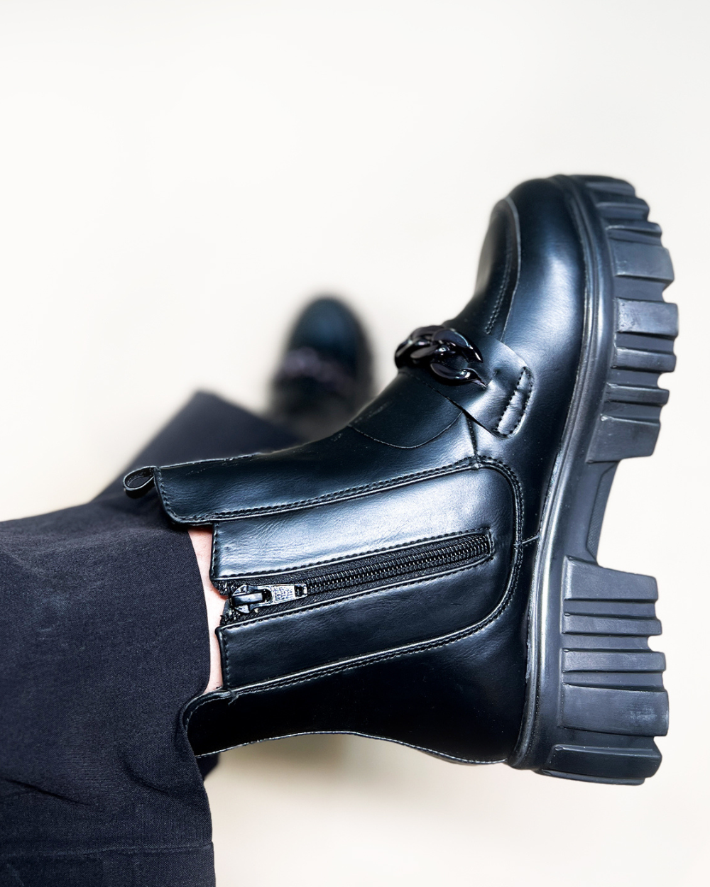 Black handcrafted side zipper ankle boots with chunky sole and front buckle detail