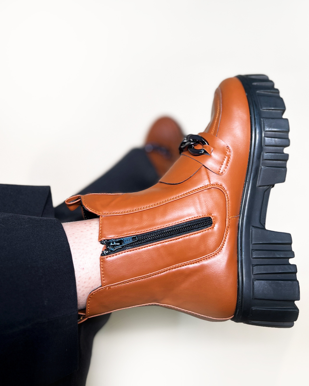 Tan handcrafted side zipper ankle boots with chunky black sole and front buckle detail