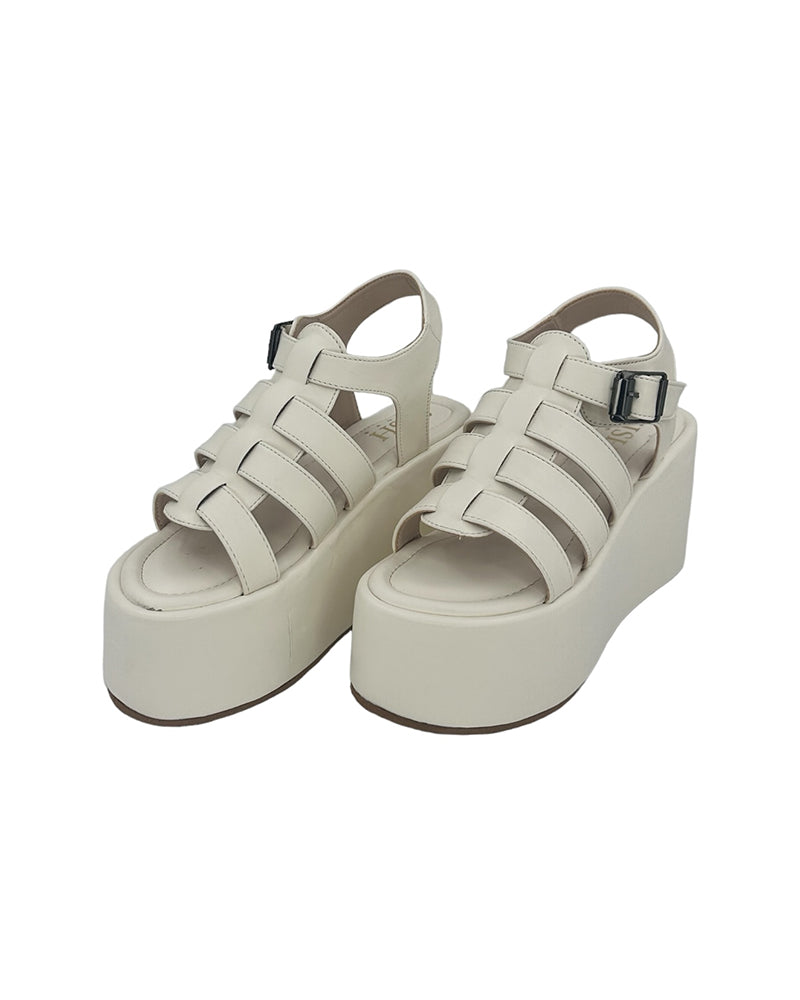White chunky heel caged platform sandals with open toe and buckle closure made of vegan leather.