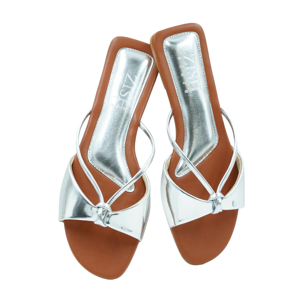 Silver Carolina Flats with glossy mirror strap and brown footbed, open-toe flat slip-on sandals for formal and casual wear.
