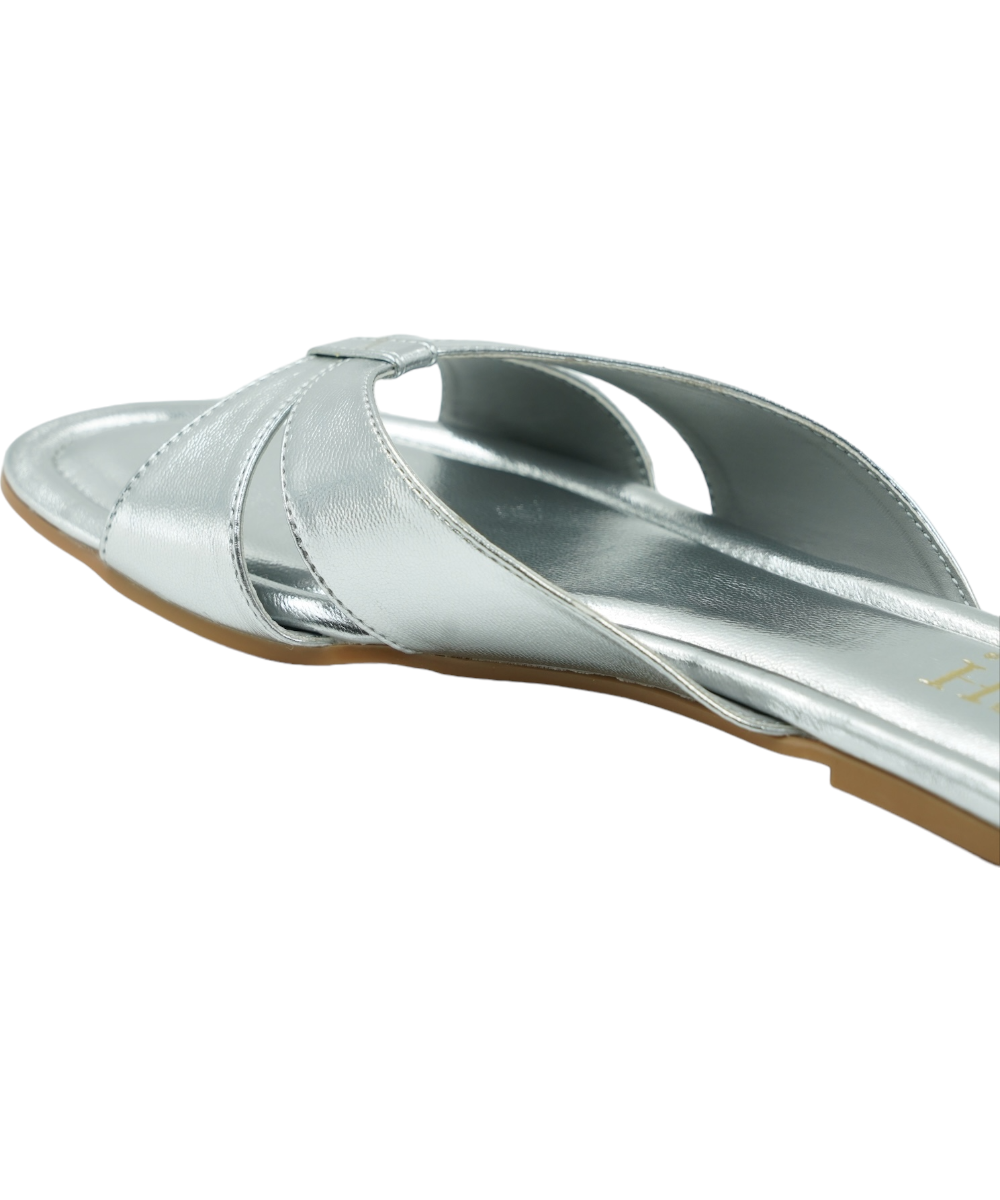Silver Tokyo Flats with cross-strap design, open-toe, flat heel, and cushioned vegan leather insole for comfort and durability.