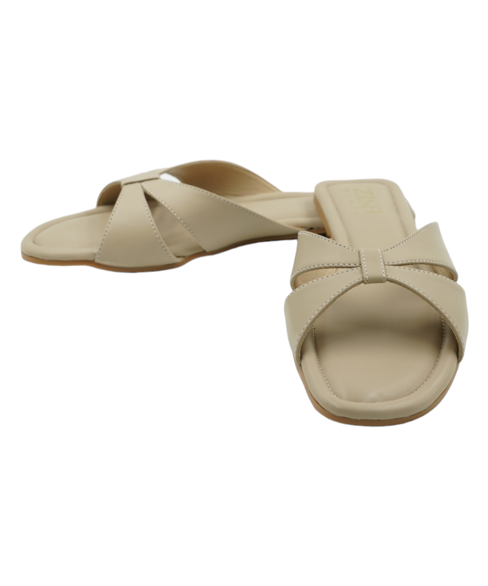 Beige Tokyo Flats with cross-strap design, open toe, and flat sole in vegan leather.