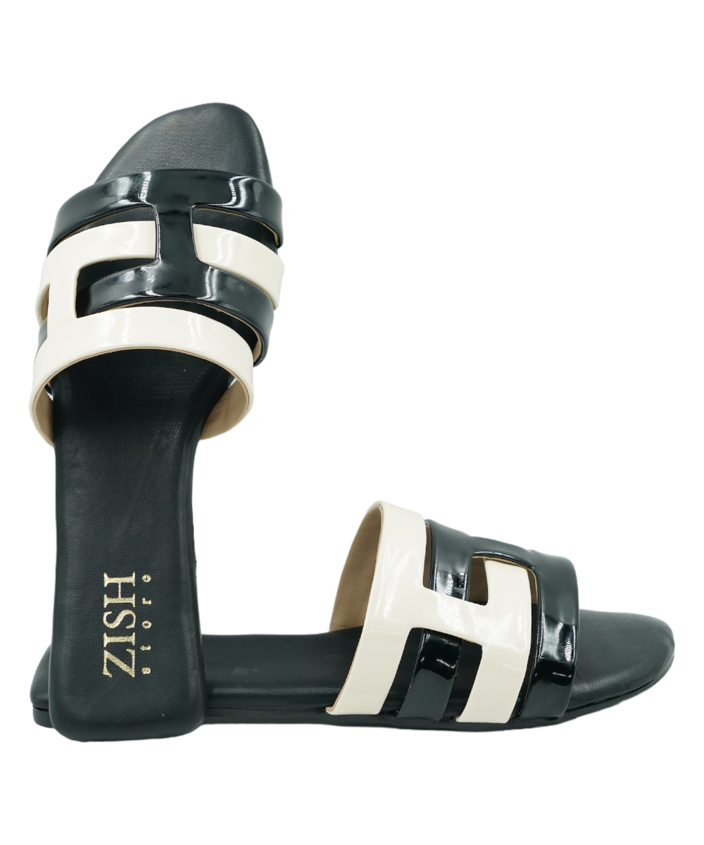 Black Azzura Flats with black and white geometric design, open toe vegan leather sandals with flat PVC sole.