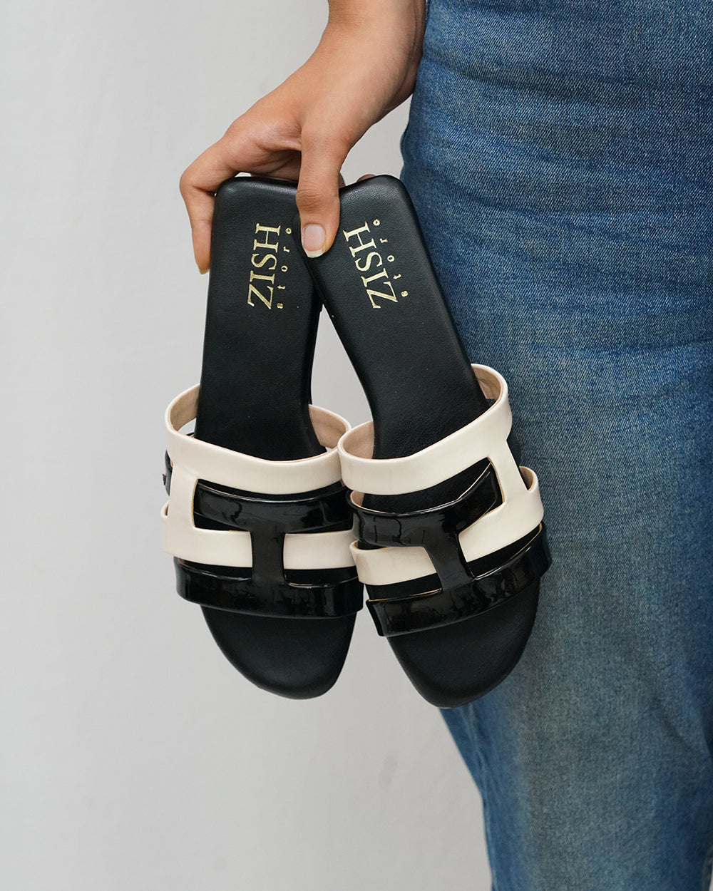 Black Azzura Flats with black and white geometric design, open toe, flat heel, and vegan leather construction.
