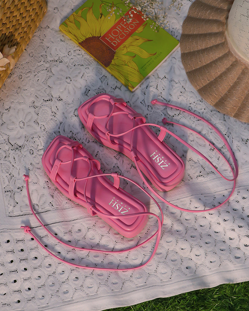 Pink Tie me Up platform sandals with 1-inch sole and lace-up straps on white lace cloth