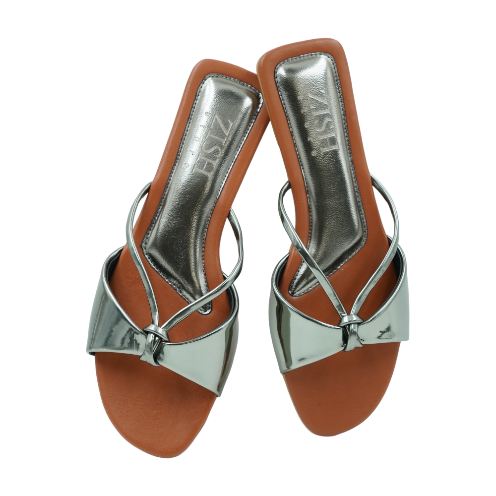 Pair of gunmetal flat sandals with glossy mirror straps and brown footbed labeled Gunmetal Carolina Flats